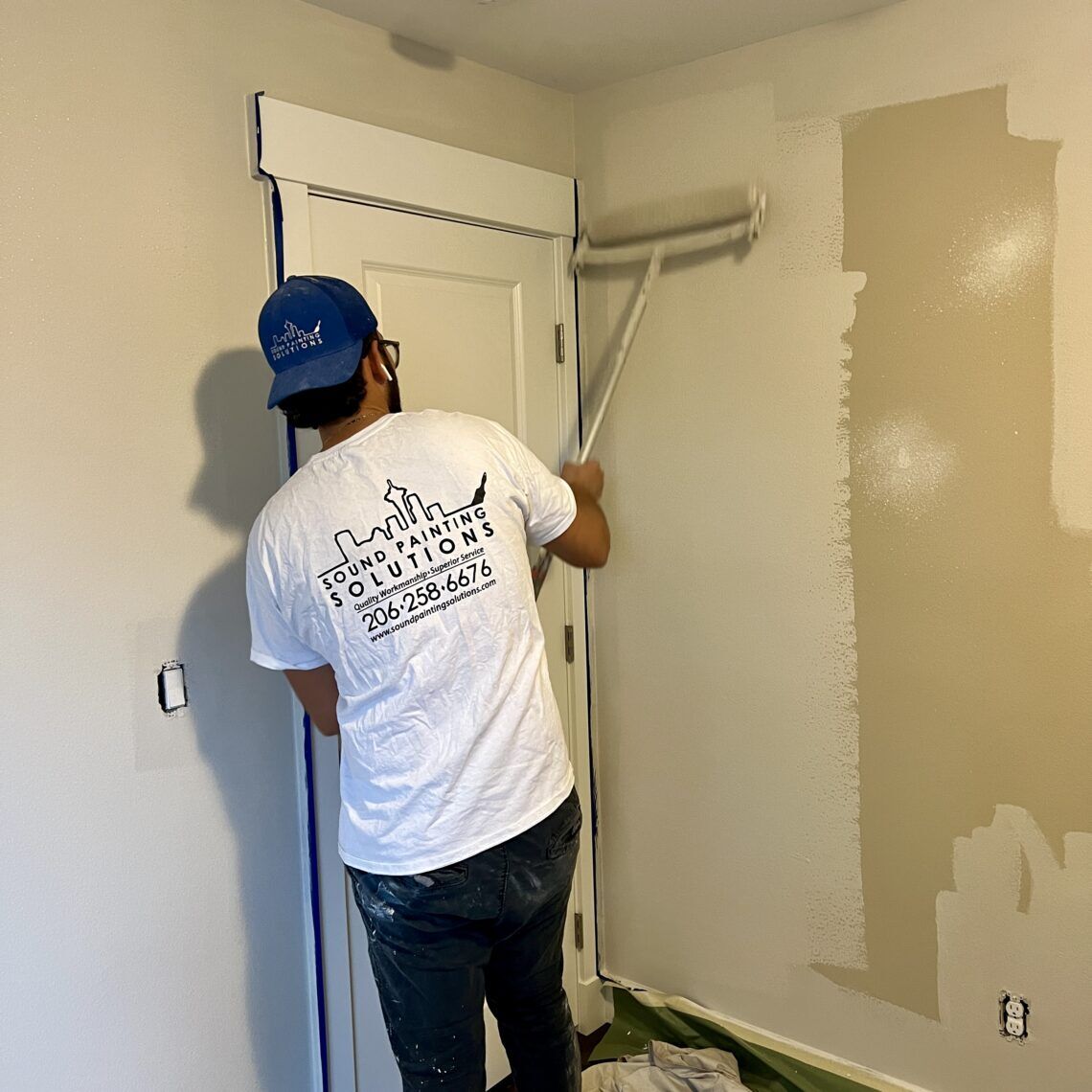 Sound Painting Solutions employee painting an interior wall