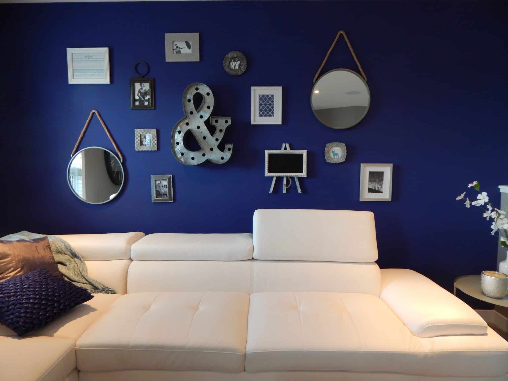 A rich blue accent wall that is also a gallery wall, by Pexels