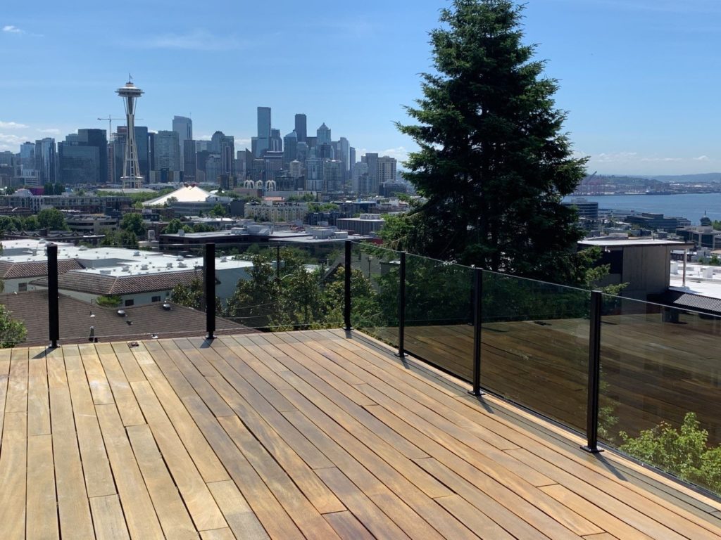 An in-progress deck staining project with a view of the Space Needle and cityscape in the background