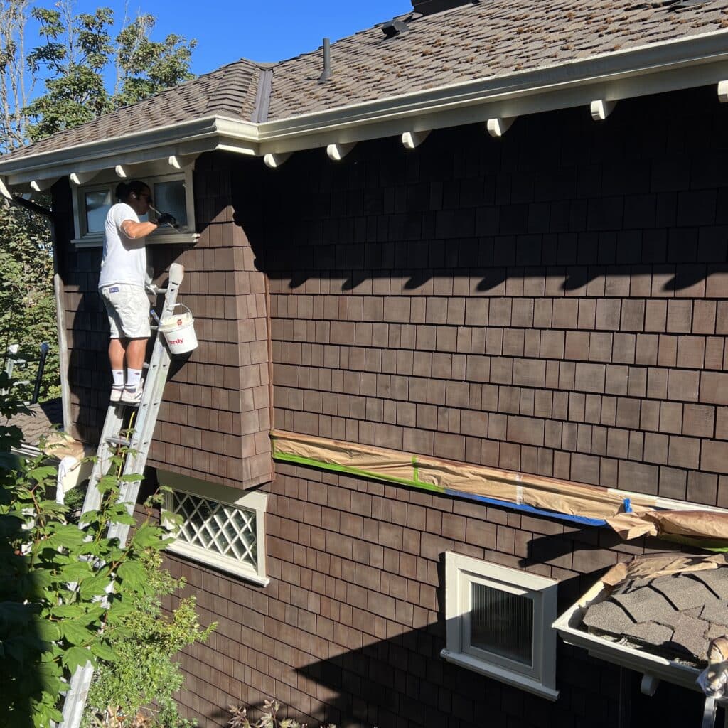 Painters applying the stain on the house. 