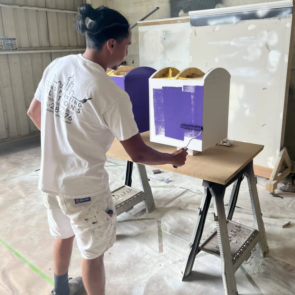 Painting the book boxes purple.