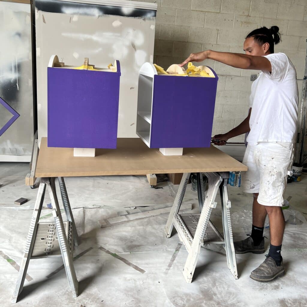 Painting the book boxes purple.