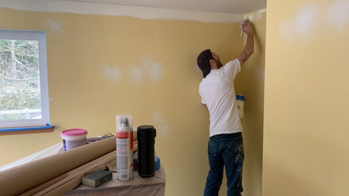 Painter cutting in the top of an interior wall